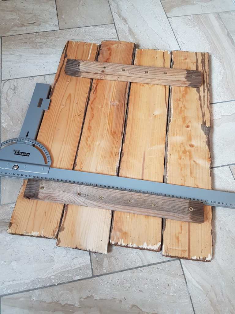 Die Altholzbretter der Sylt Wanduhr werden ausgerichtet und verschraubt. 