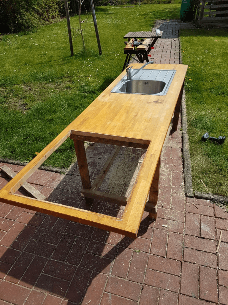 Die Arbeitsplatte wird mit dem Unterbau der Matschküche verbunden